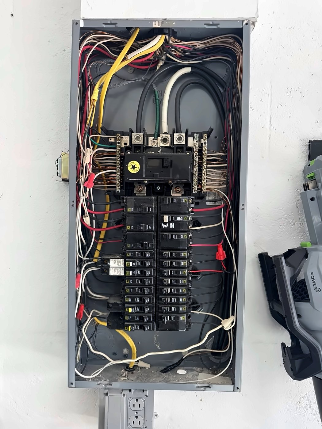 Main electrical panel with the cover off, showing breakers and wiring